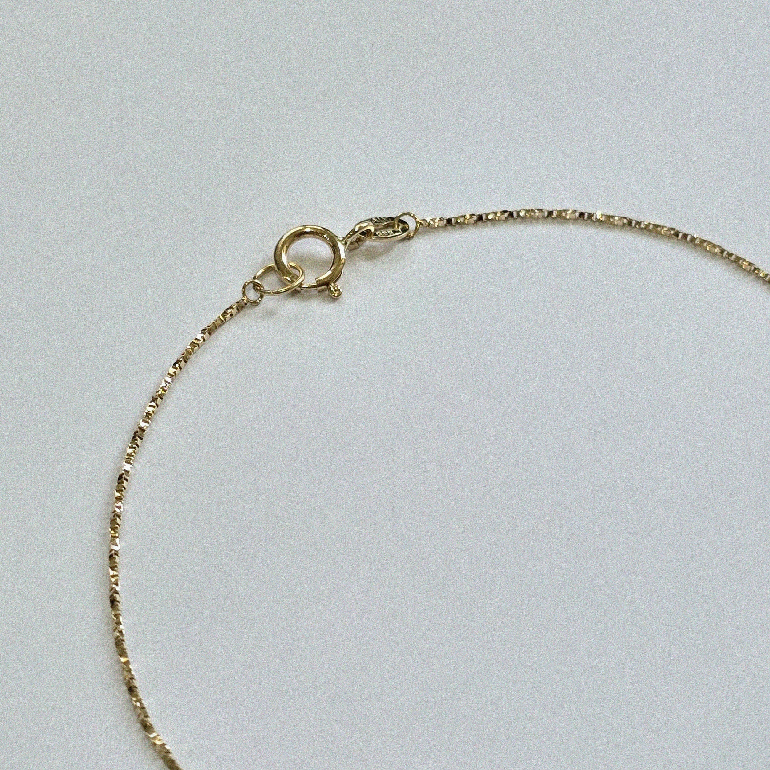 Detail shot of 14K gold clasp and luminous chain finish