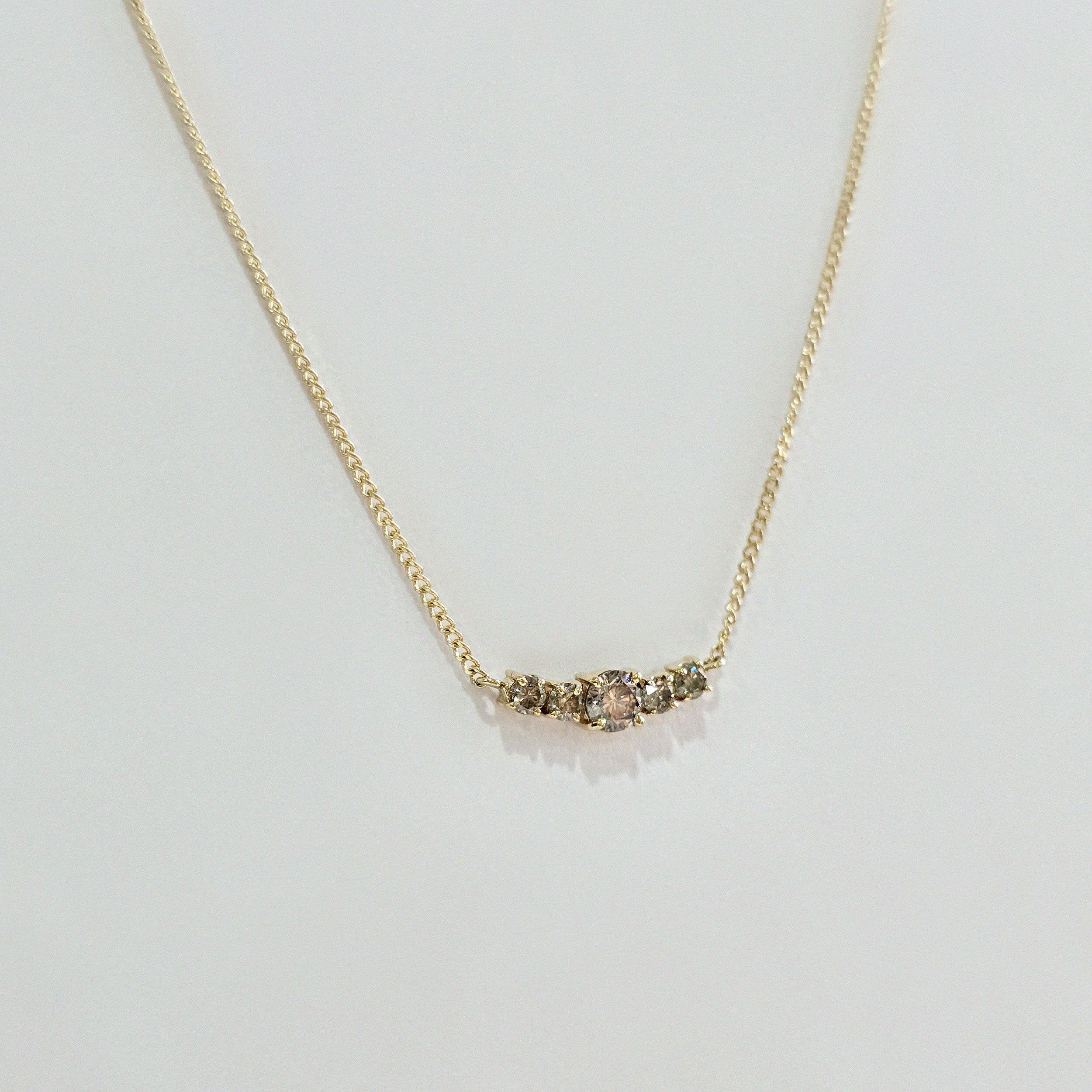Overhead view of diamond cluster pendant glistening under light – fine craftsmanship in solid gold