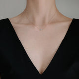 Necklace styled with V neck black top – fine diamond pendant adds sparkle to everyday look