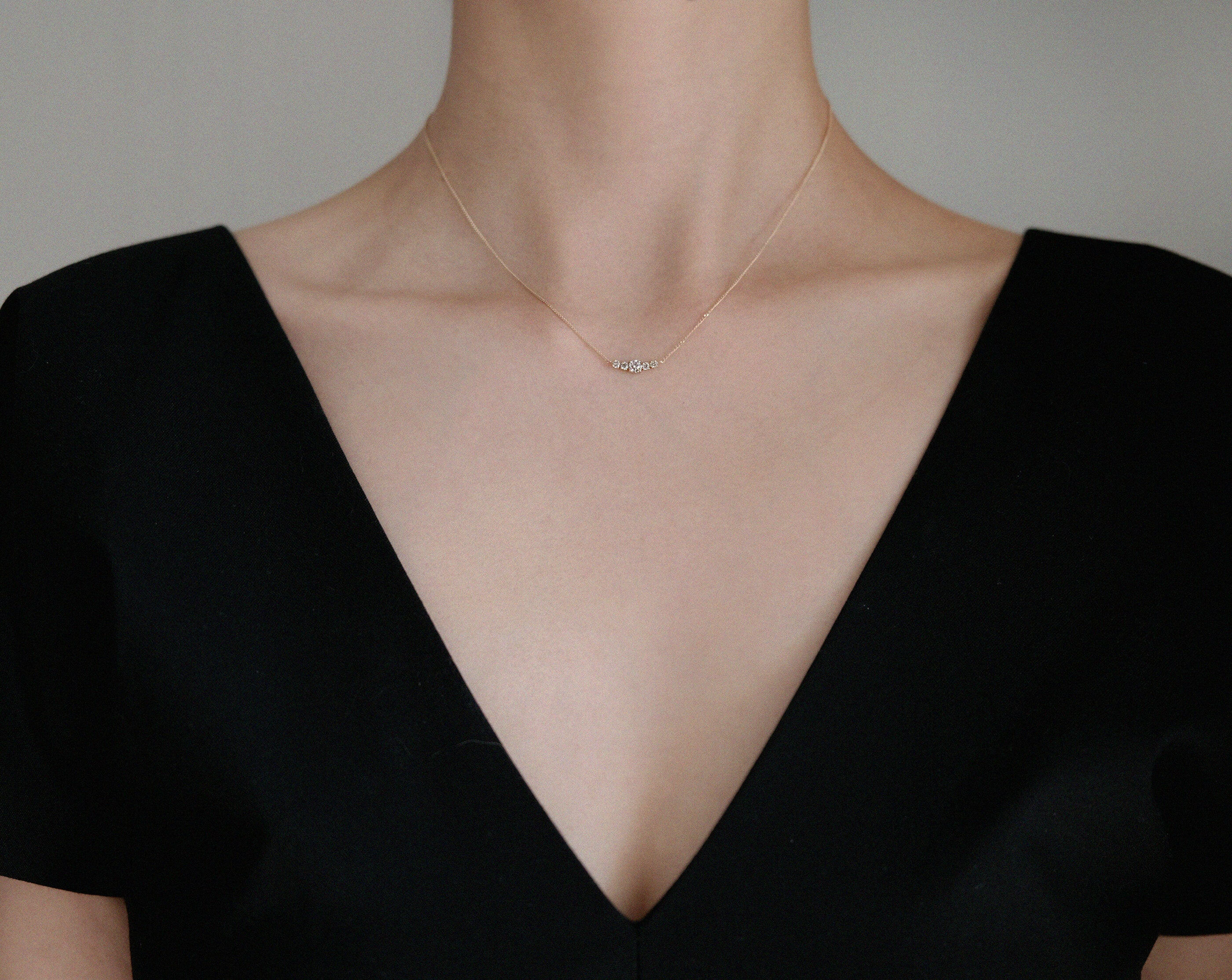 Necklace styled with V neck black top – fine diamond pendant adds sparkle to everyday look