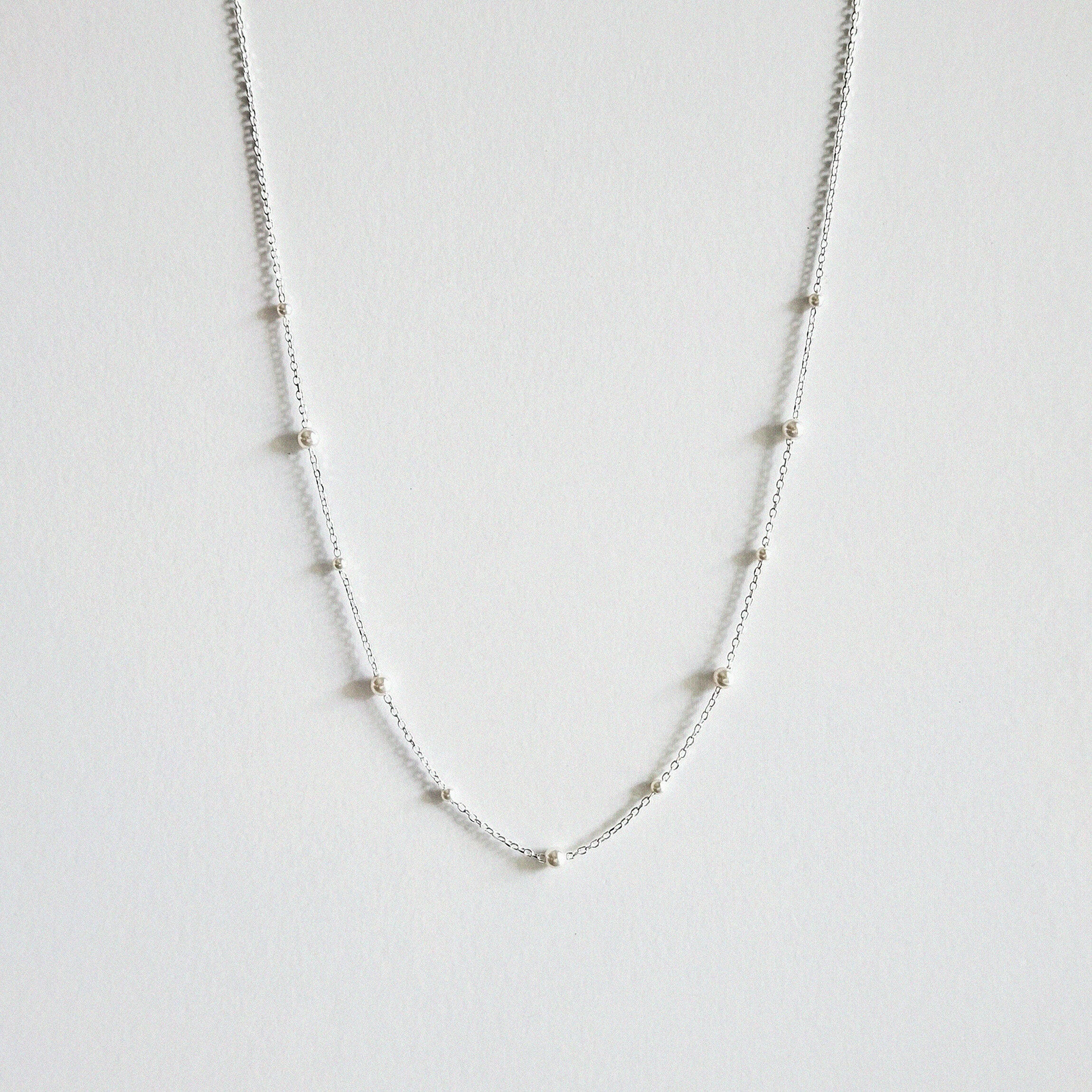 Mixed pearls necklace laid flat showing graduated Swarovski pearls on a delicate silver chain