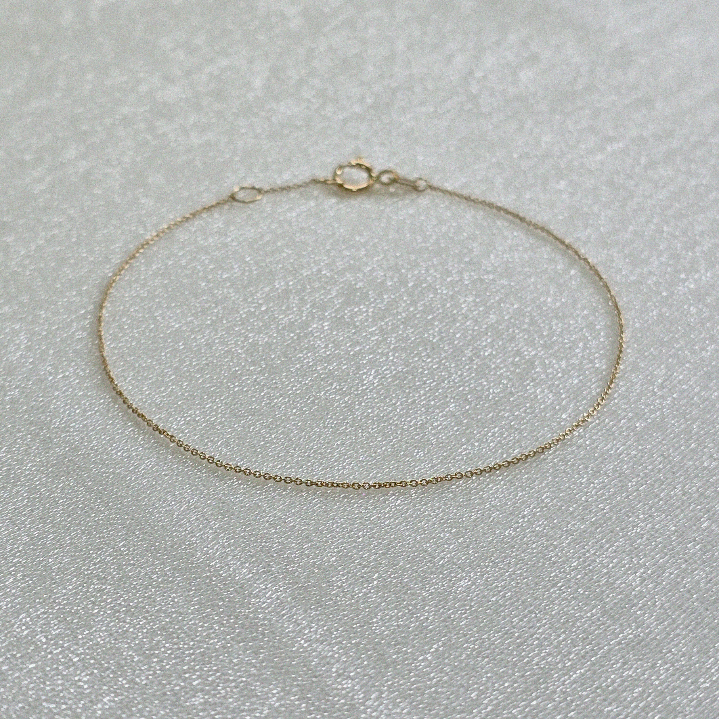 Delicate Paris link bracelet laid out to show fine detail and shine