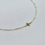 Minimalist gold bracelet featuring a 4mm x 5mm cross on a fine chain