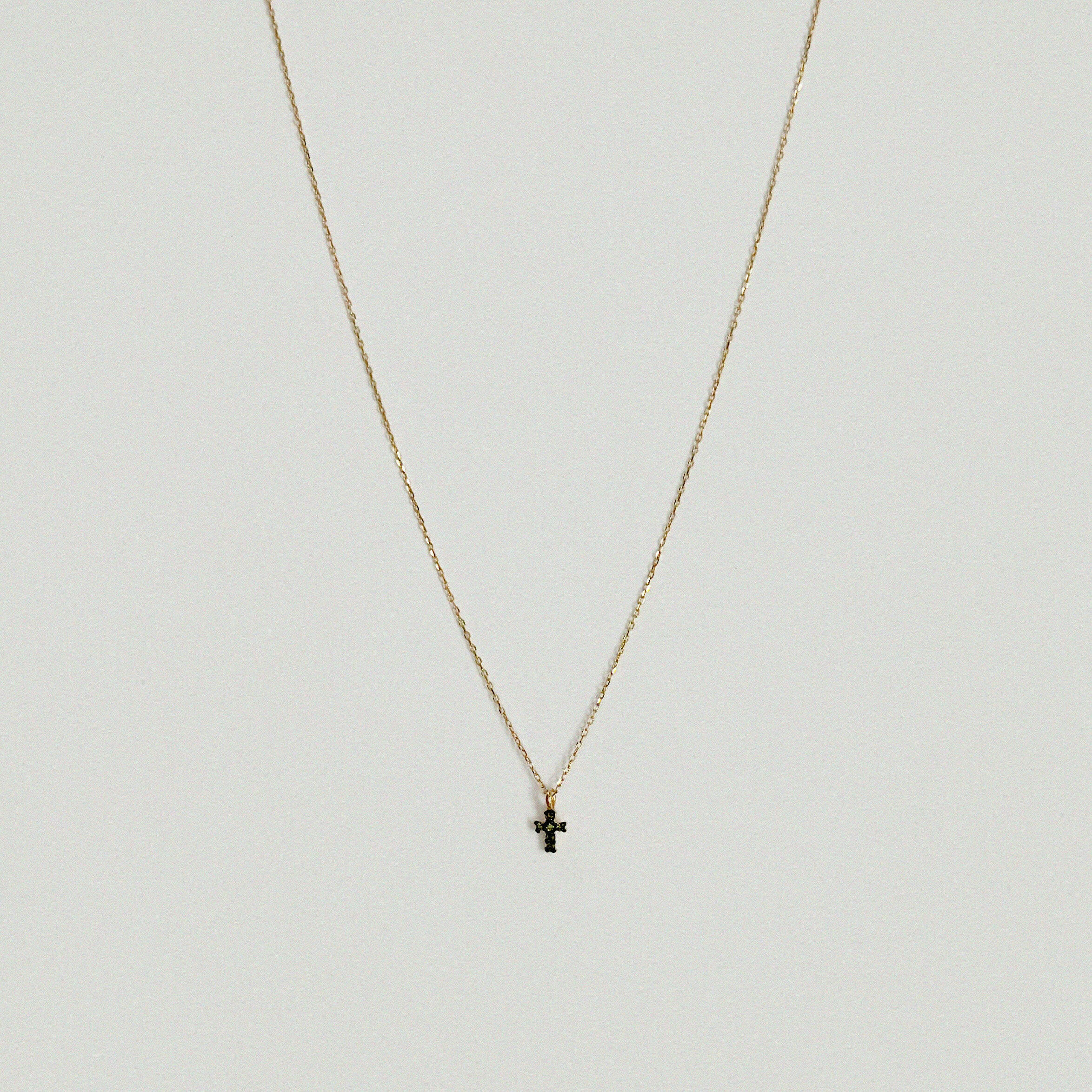 Close-up of 14K gold cross pendant with 4mm–7.5mm diamond in high-polish finish