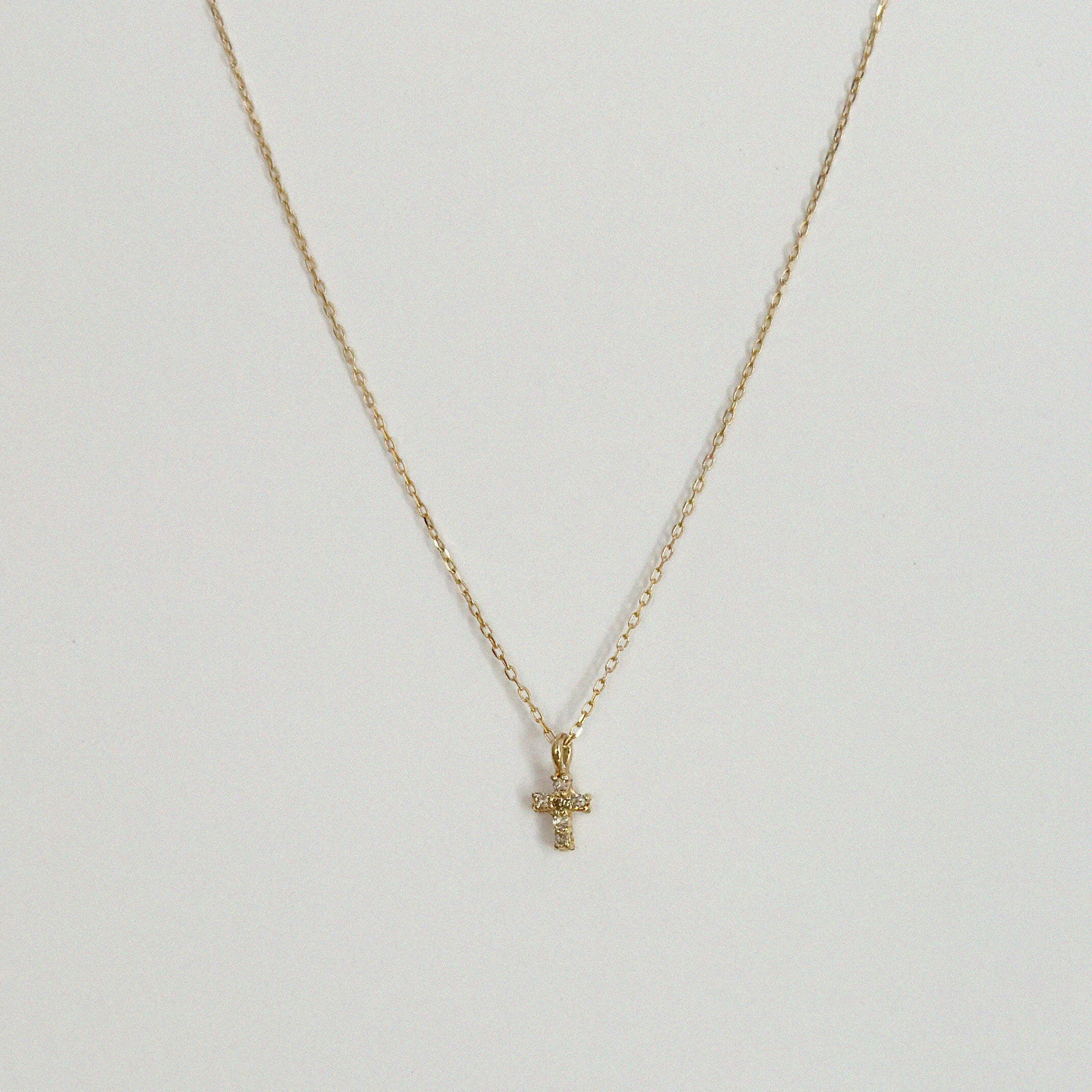 Close-up of 14K gold cross pendant with 4mm–7.5mm diamond in high-polish finish