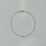 Delicate diamond bracelet laid flat, showing subtle sparkle on fine gold chain
