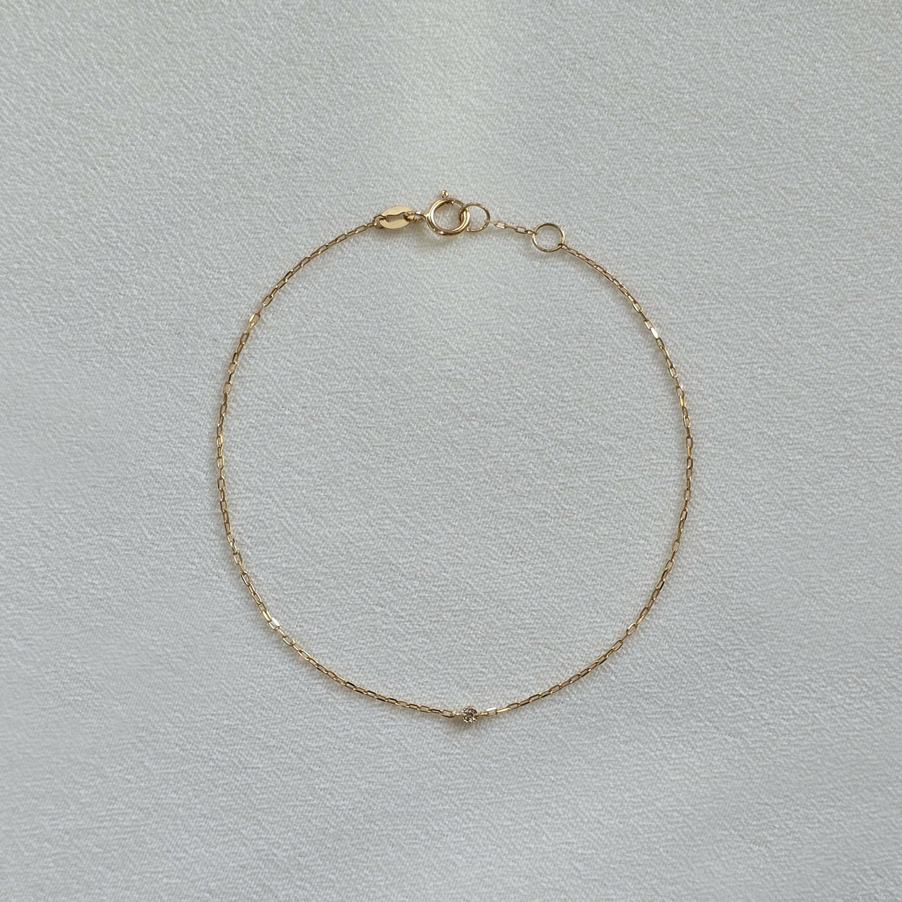 Delicate diamond bracelet laid flat, showing subtle sparkle on fine gold chain