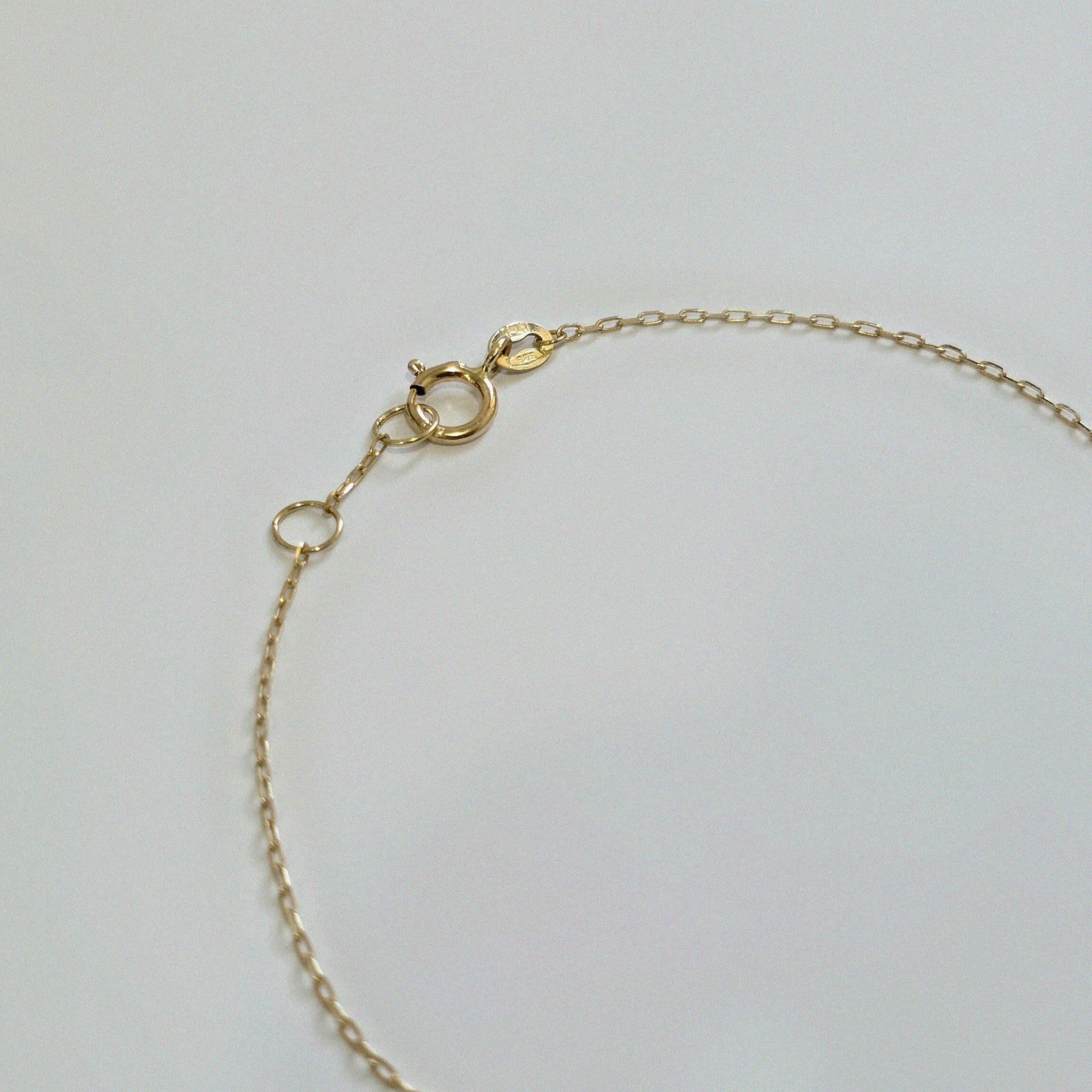 Detailed image of clasp and center diamond on fine chain bracelet