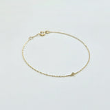 Delicate diamond bracelet laid flat, showing subtle sparkle on fine gold chain
