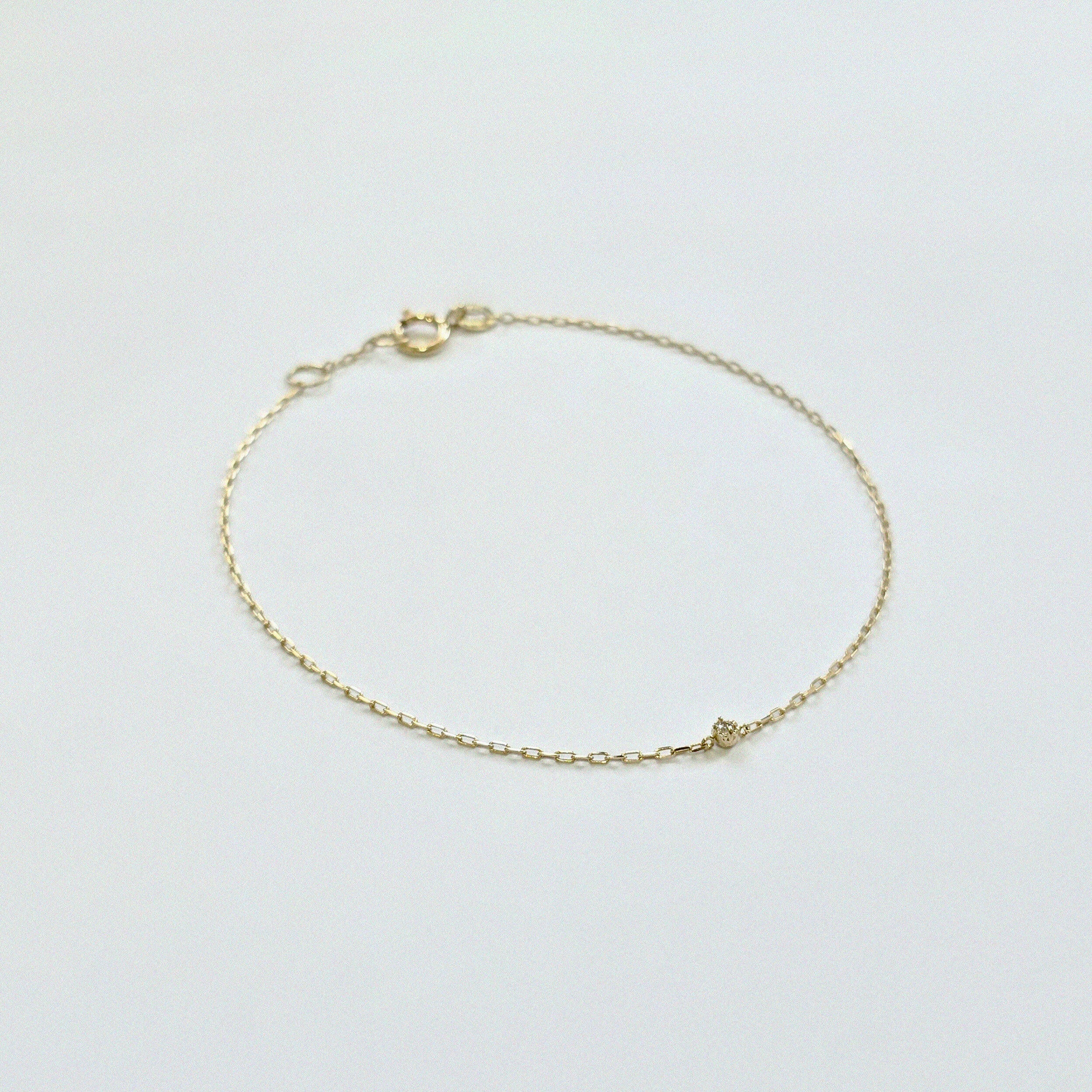 Delicate diamond bracelet laid flat, showing subtle sparkle on fine gold chain
