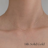 Necklace worn by model with bare neckline, highlighting minimalist sparkle
