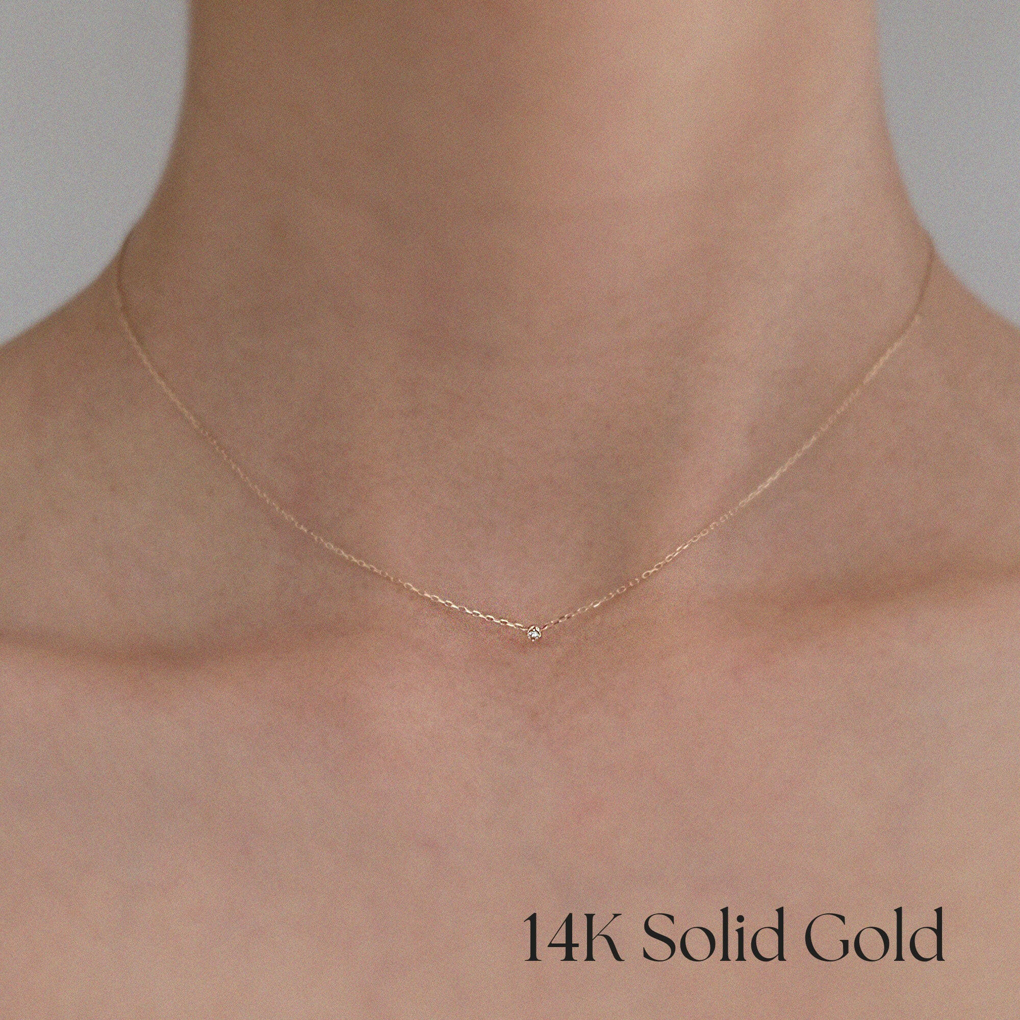 Necklace worn by model with bare neckline, highlighting minimalist sparkle