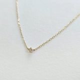 Angled side view showing diamond depth and chain texture in 14K gold
