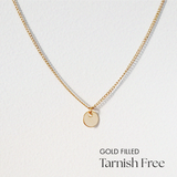 Delicate gold filled disc necklace laid flat with pendant centered