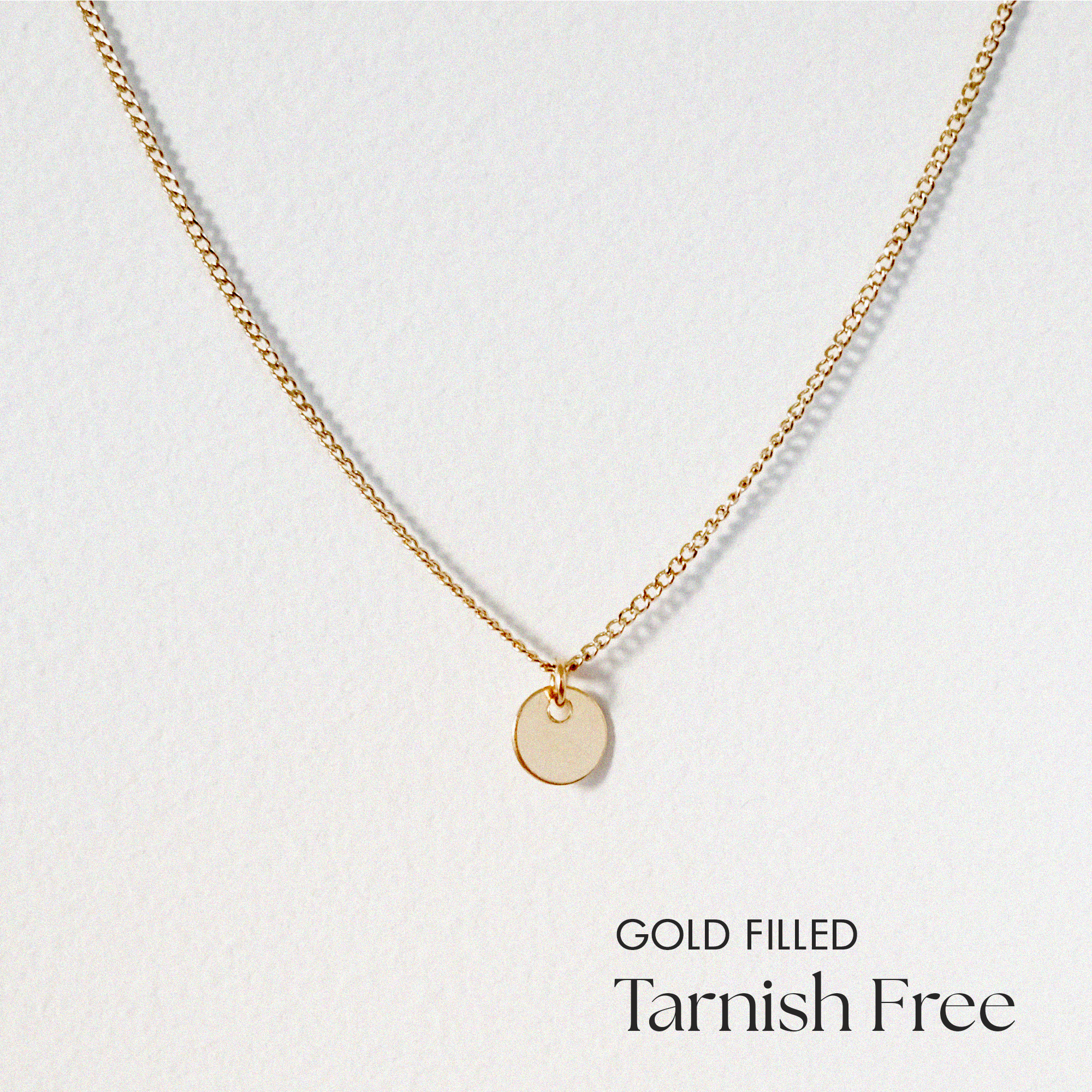 Delicate gold filled disc necklace laid flat with pendant centered
