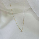 Side perspective capturing the gentle curve of the pearl and chain texture