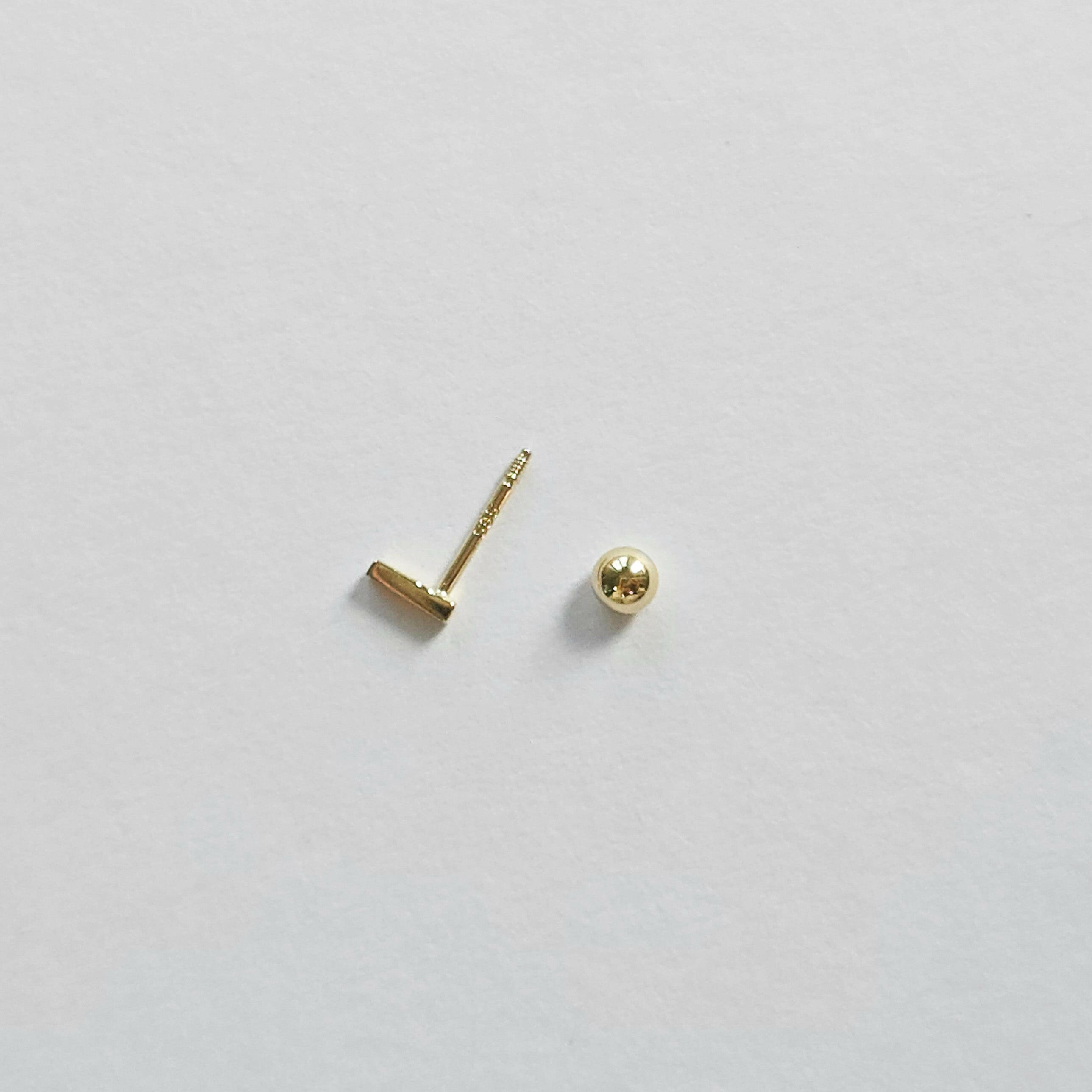 Screwball back and post detail of gold bar cartilage stud