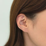 14K gold horizontal bar cartilage earring worn on low helix piercing