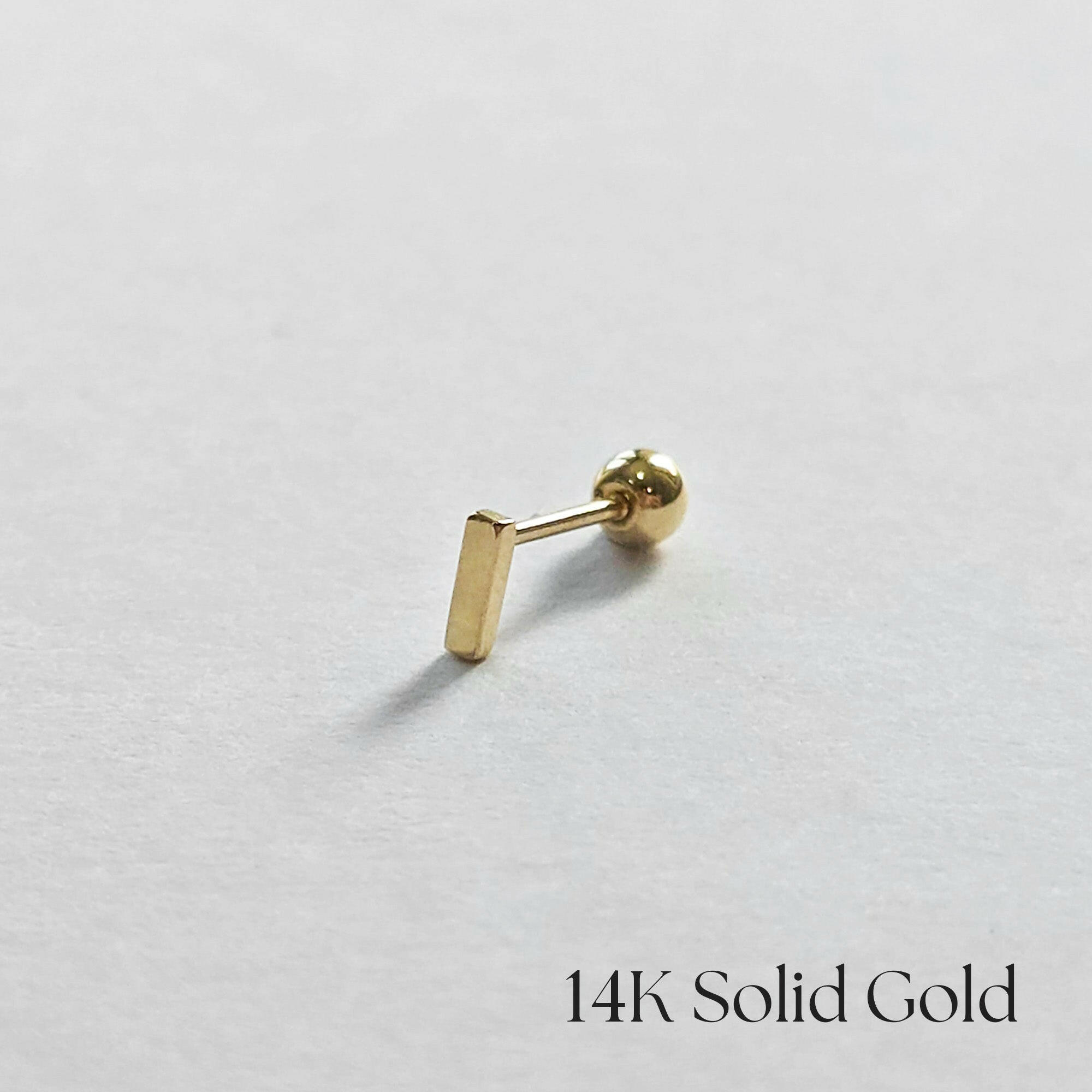 Side profile of 14K gold bar cartilage earring with minimalist design