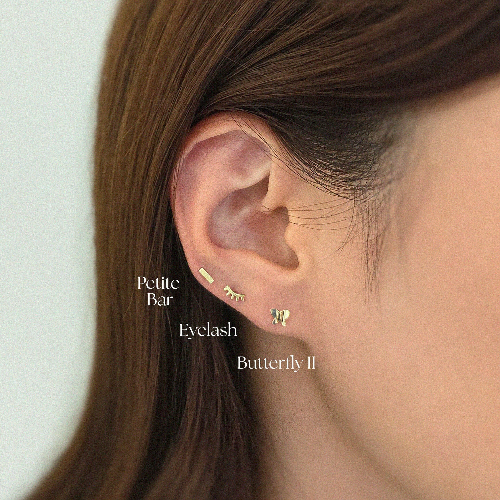 Petite bar cartilage stud paired with gold stud earring in curated stack