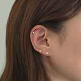 CZ cartilage stud styled in upper helix with gold studs