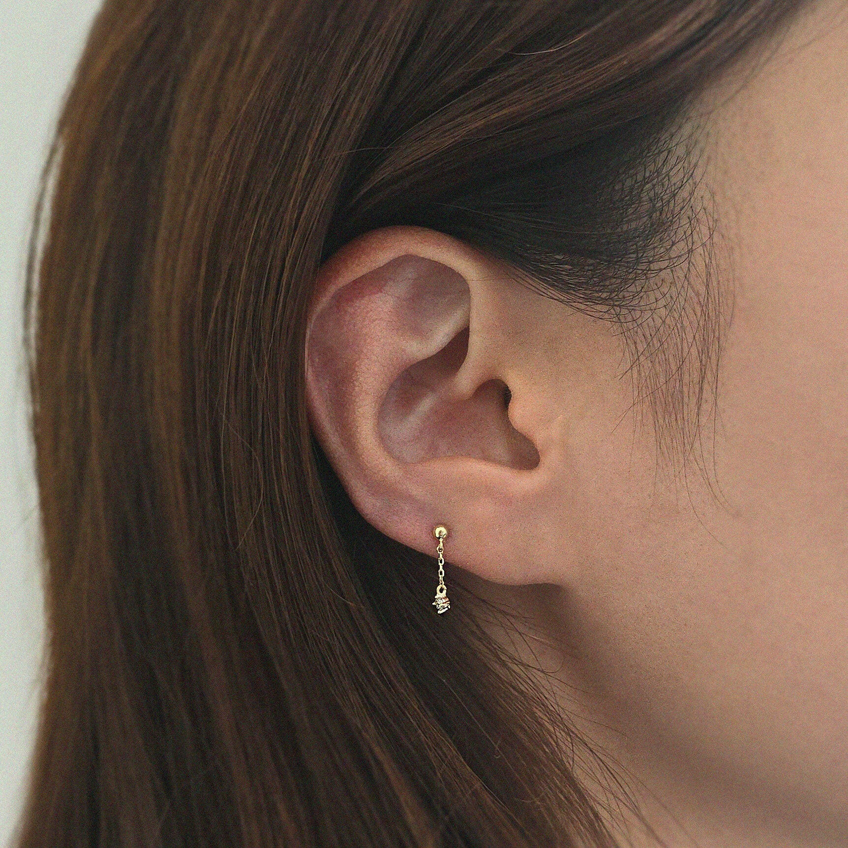 Crystal chain cartilage earring on model’s ear showing subtle dangle and fit