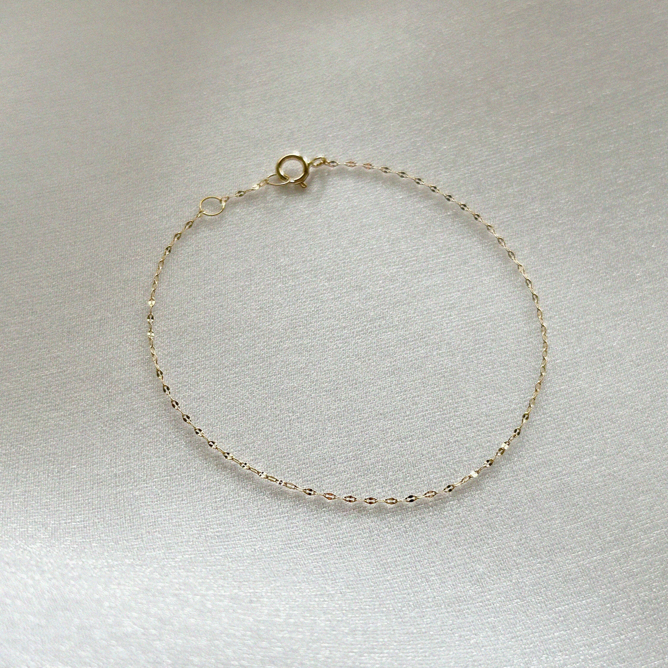 Minimalist gold chain bracelet laid flat to highlight its delicate design
