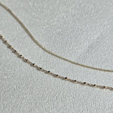 Minimalist bracelets styled in a flat-lay on neutral display background