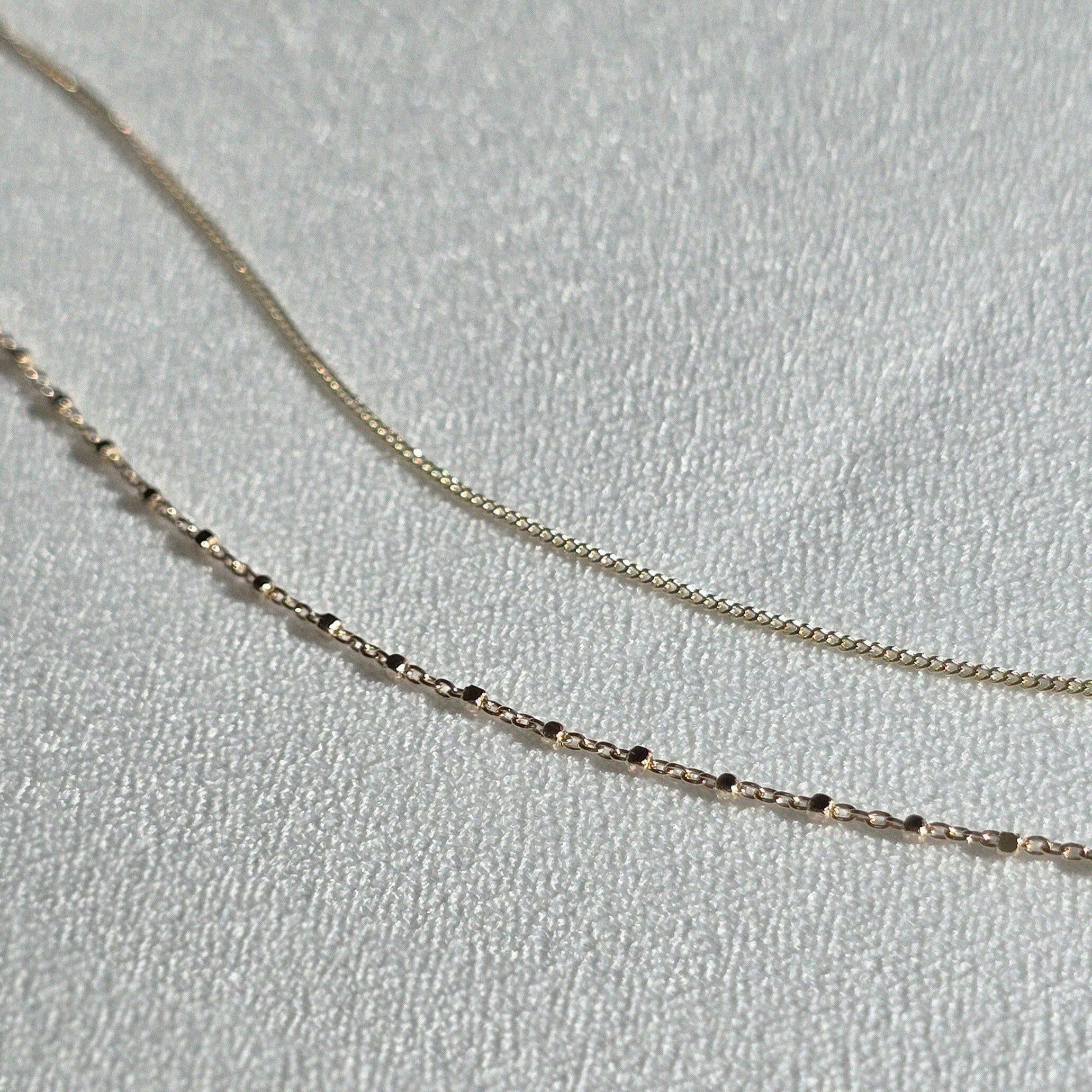 Minimalist bracelets styled in a flat-lay on neutral display background