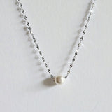 Single pearl necklace exemplifying elegant minimalism, perfect for timeless and sophisticated style.