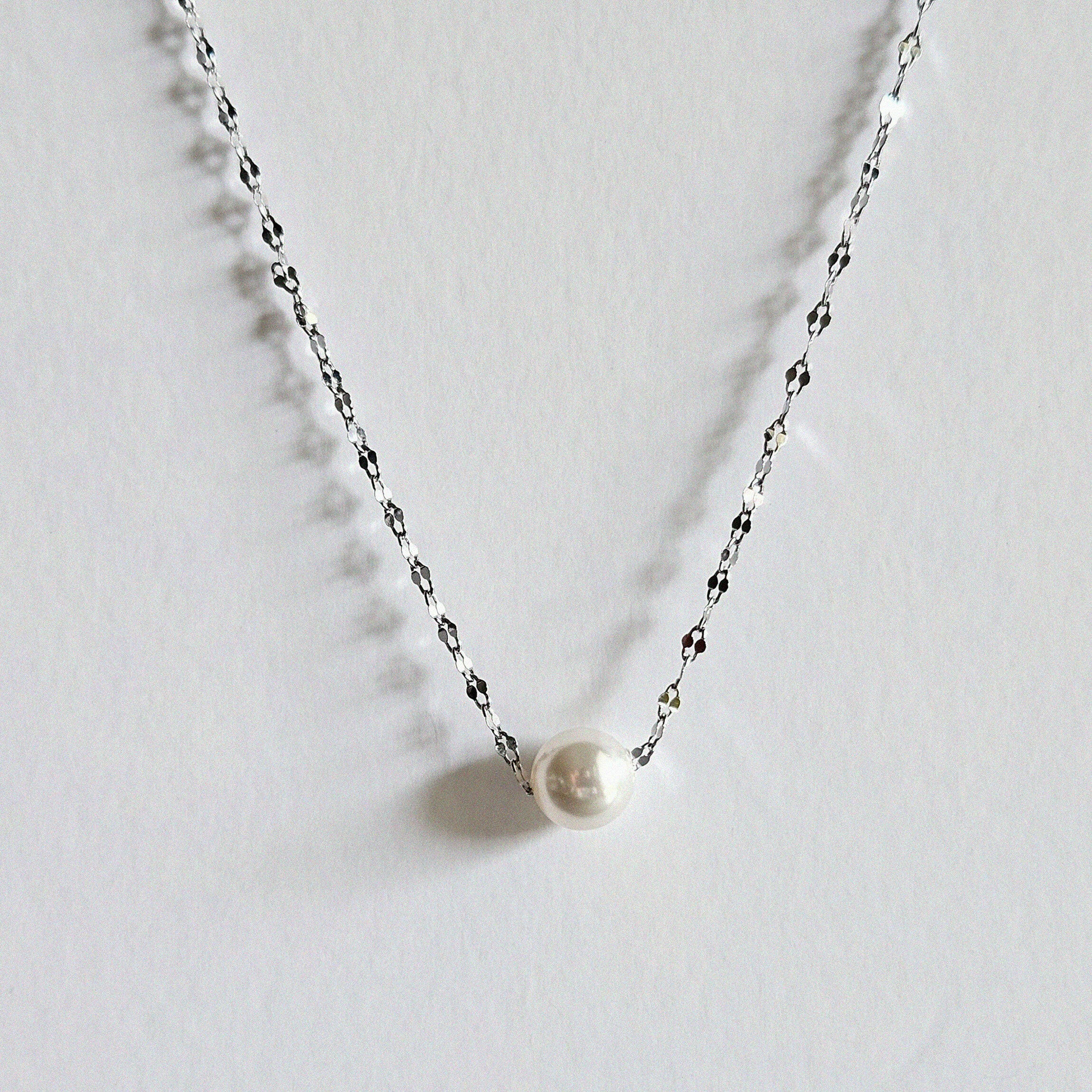 Single pearl necklace exemplifying elegant minimalism, perfect for timeless and sophisticated style.