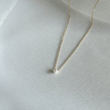 Side-angle view highlighting the pearl’s dimension and the chain’s sheen