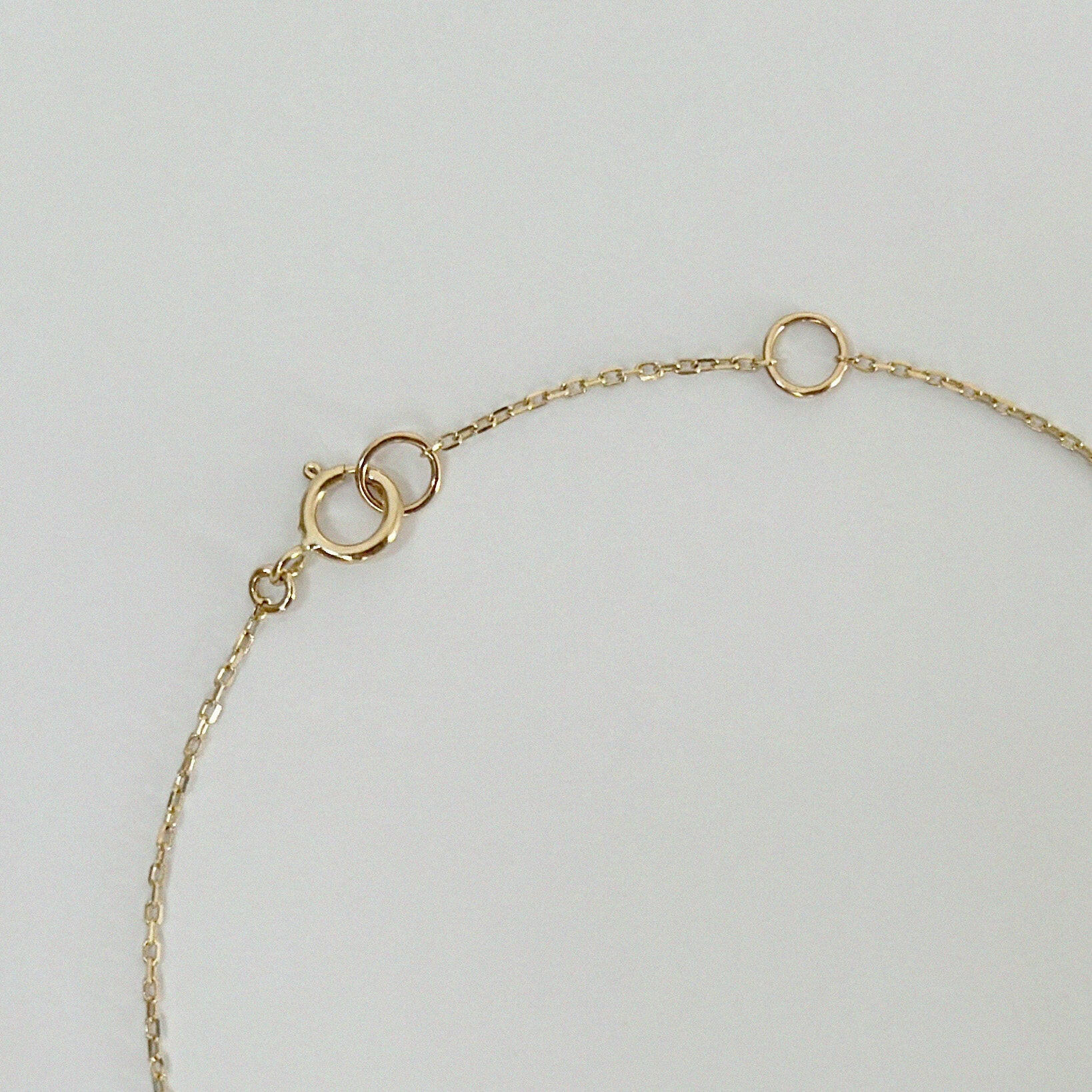 Aurora Labradorite Necklace spring clasp and extender rings crafted in 14K yellow gold, displayed against a soft white background