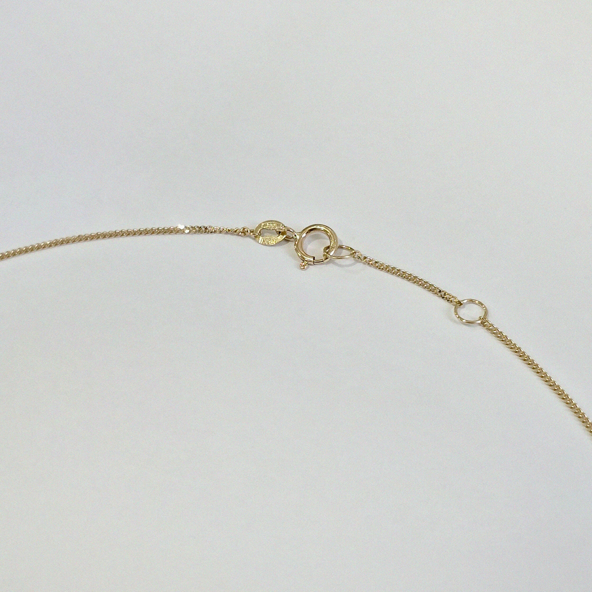Close-up of 14K gold spring clasp and extender chain – secure and adjustable closure