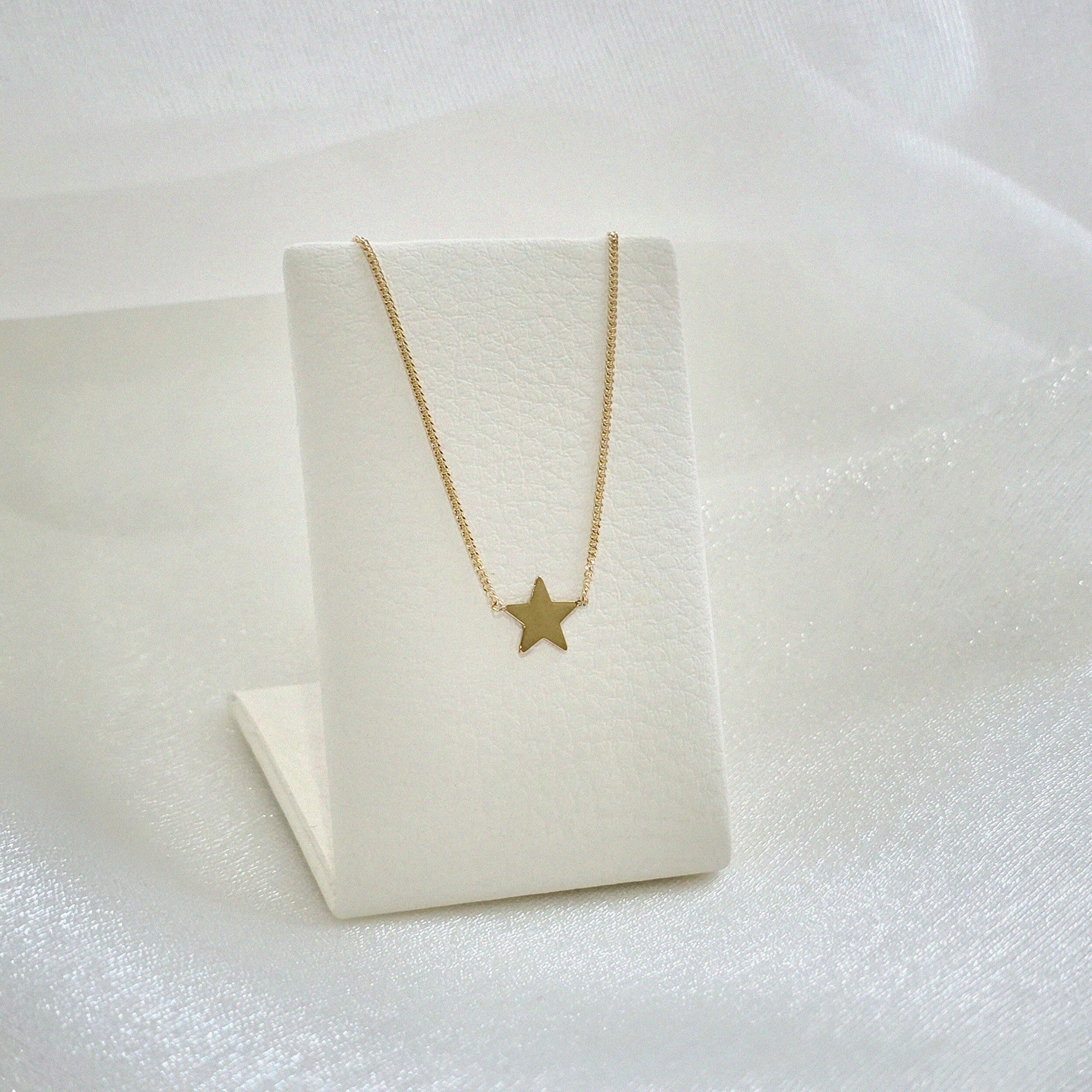 Stella Mia Necklace displayed on white ㅣleather necklace stand – celestial charm highlighted