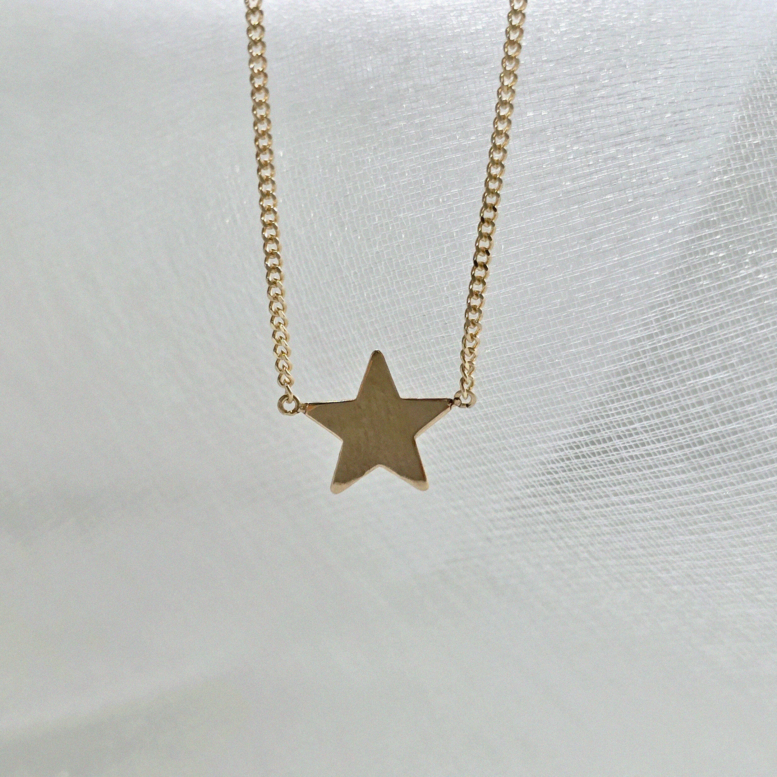 Beveled edges of star pendant glistening in studio light