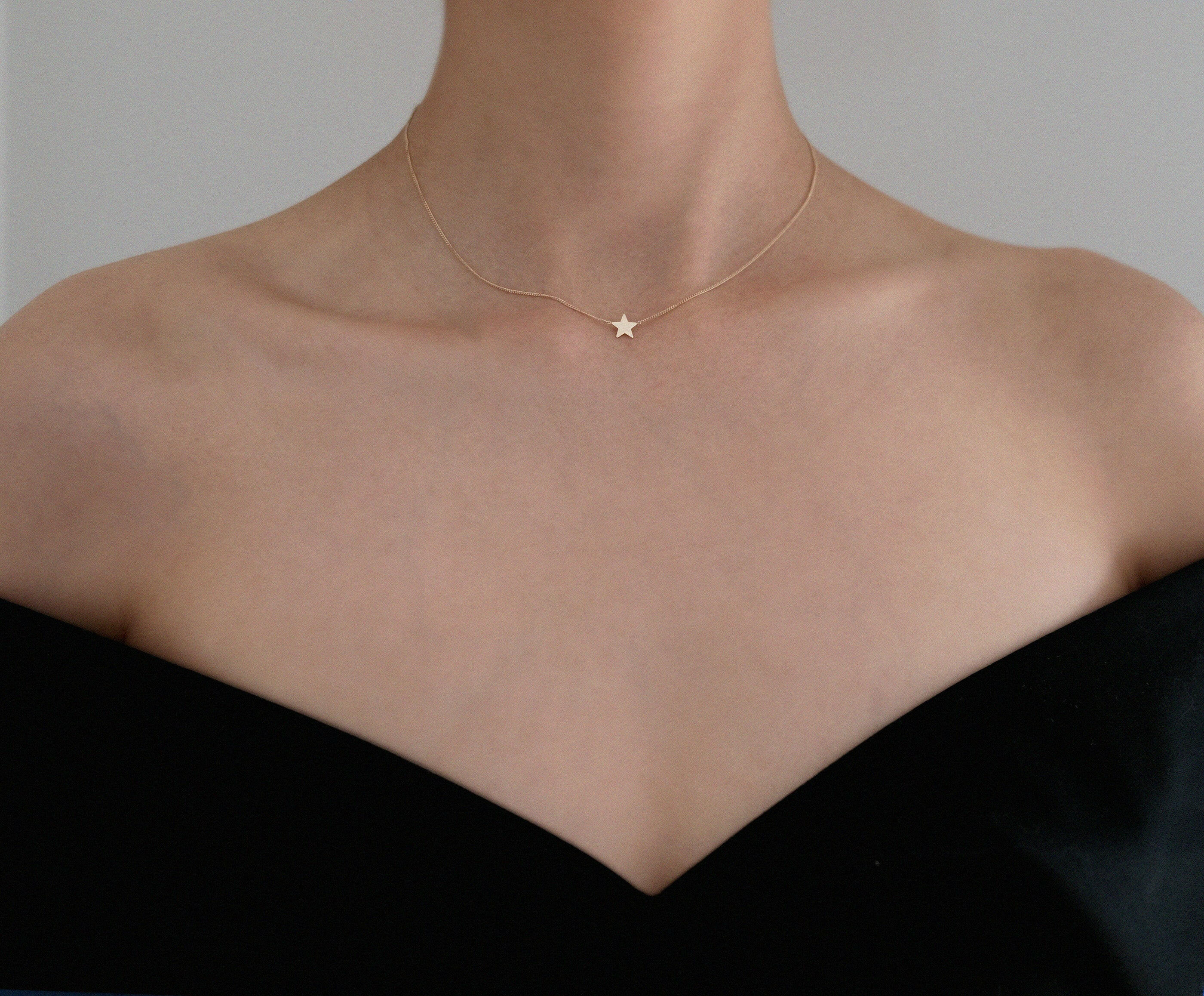 Model wearing Stella Mia Star Necklace styled with black off-shoulder top – celestial elegance