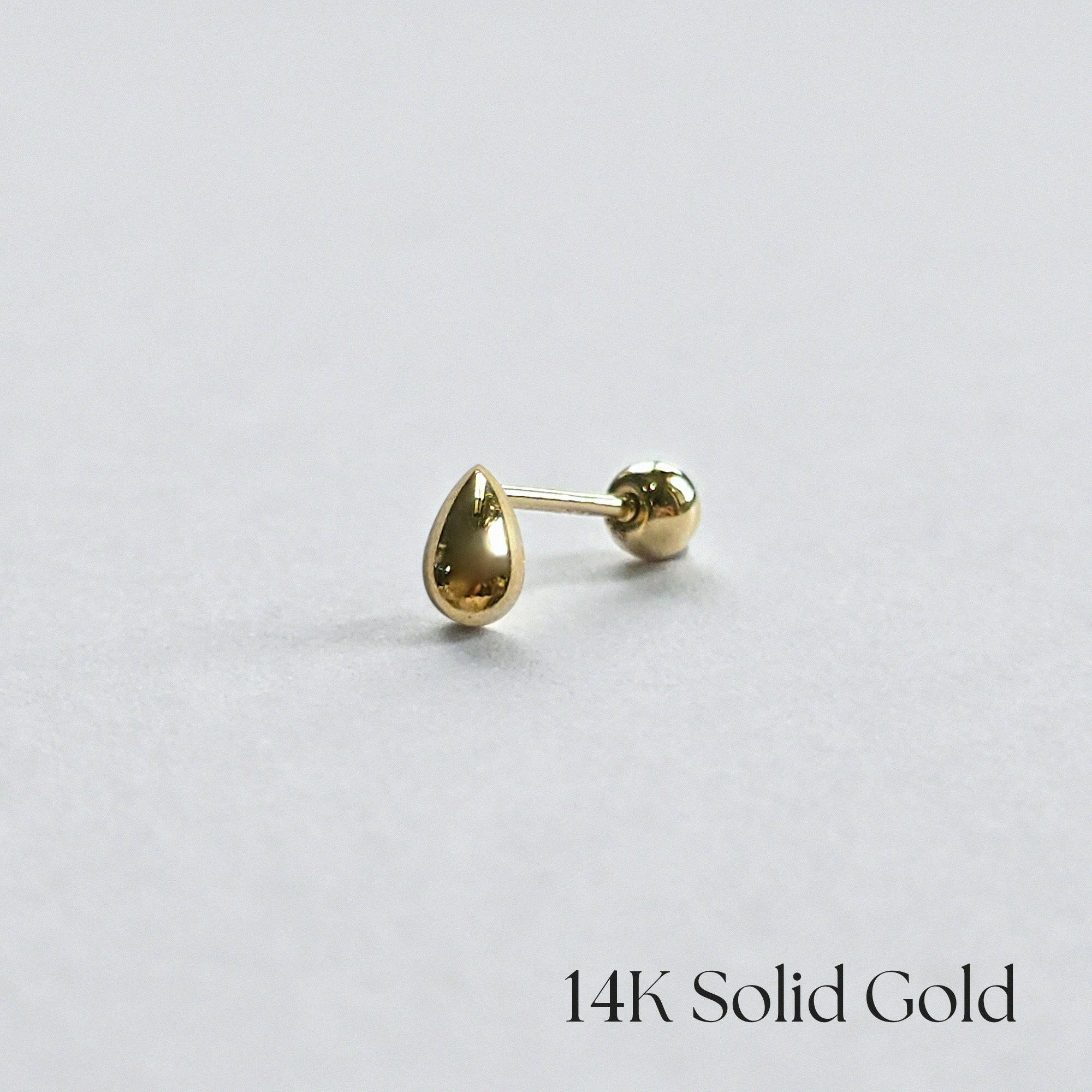 Side-angle view of 14K gold teardrop cartilage earring on clean white background