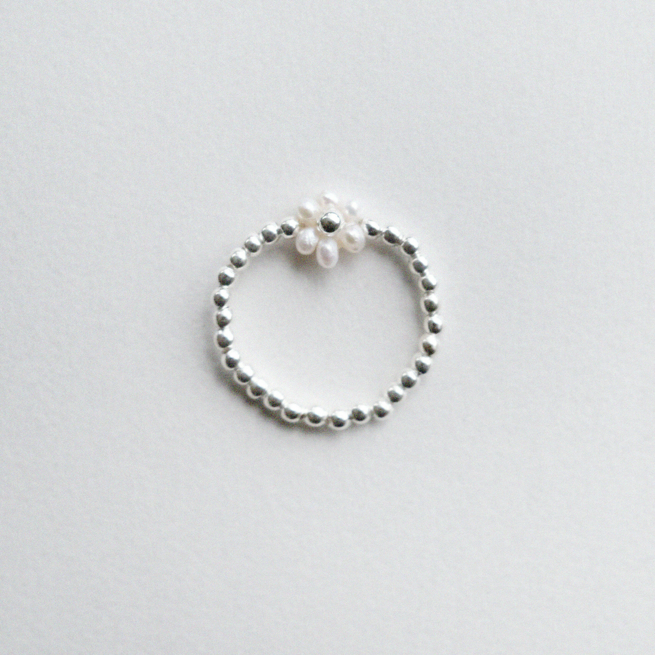 Delicate flower-shaped pearl ring with silver beads, elegant pearl jewelry perfect for formal occasions