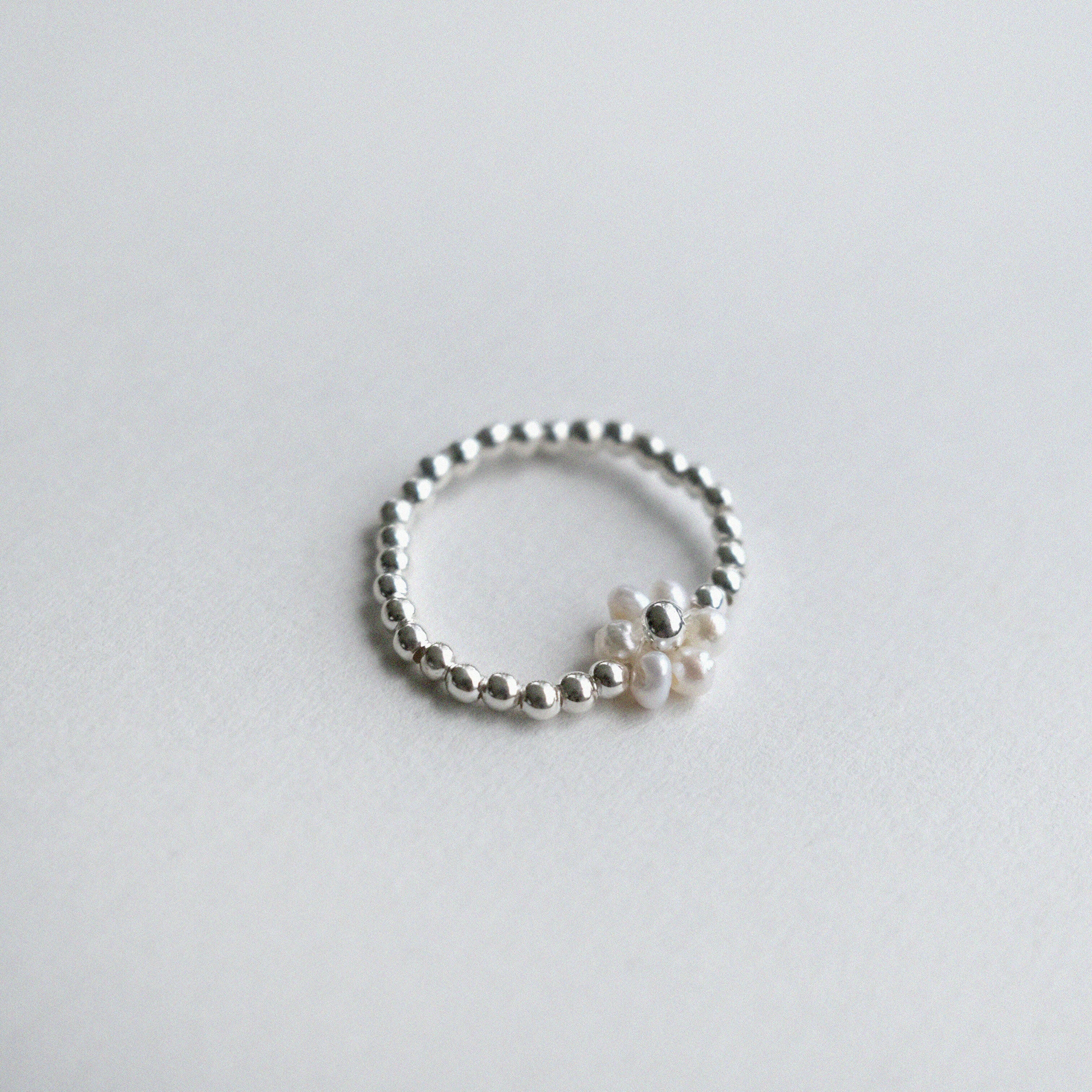 Delicate flower-shaped pearl ring with silver beads, elegant pearl jewelry perfect for formal occasions