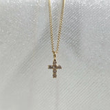 Overhead close-up of dainty diamond cross pendant – minimal and elegant