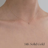 Model wearing Tiny Diamond Croce Necklace – pendant resting near collarbone