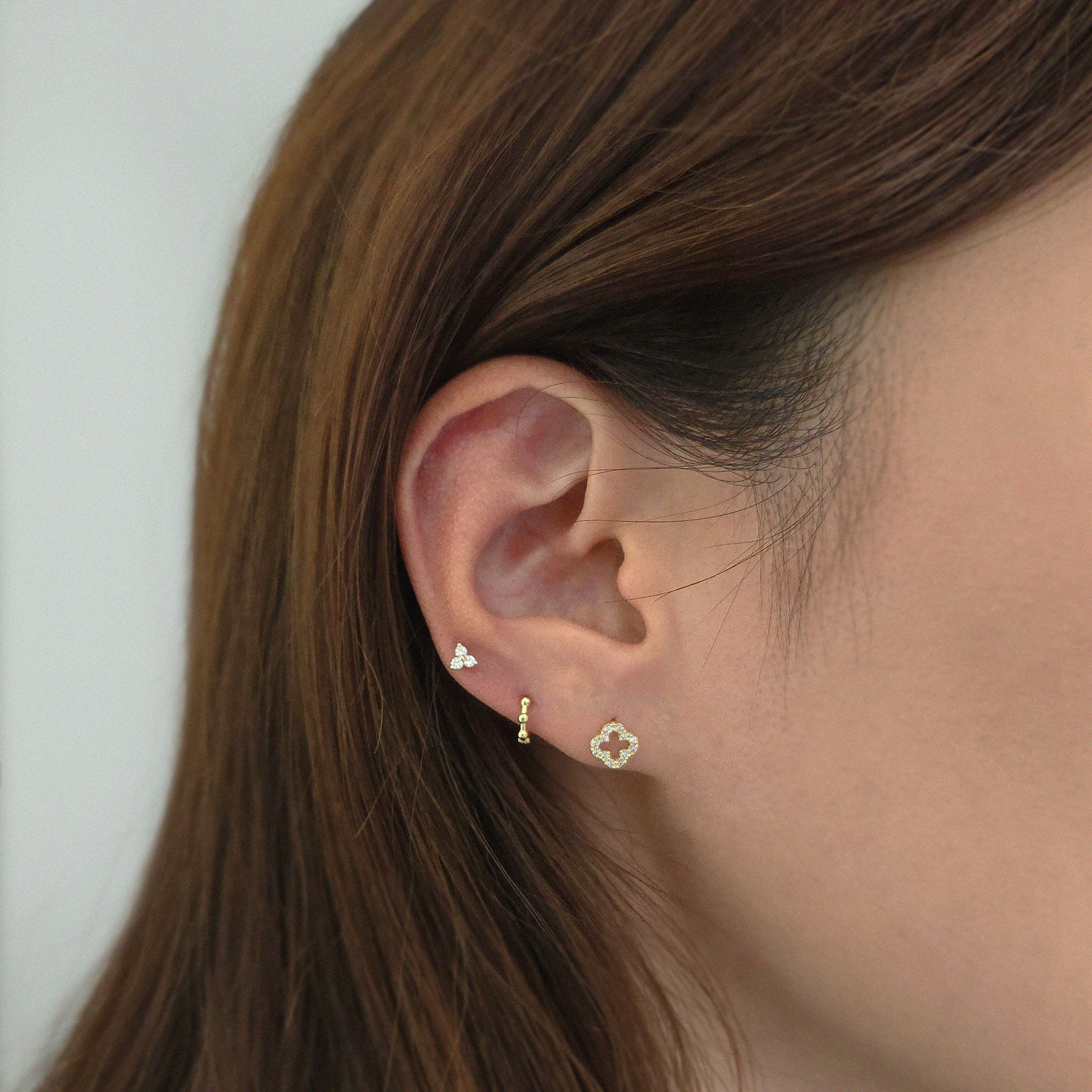 Trio Crystal Earring styled with other 14K cartilage in a curated ear look.