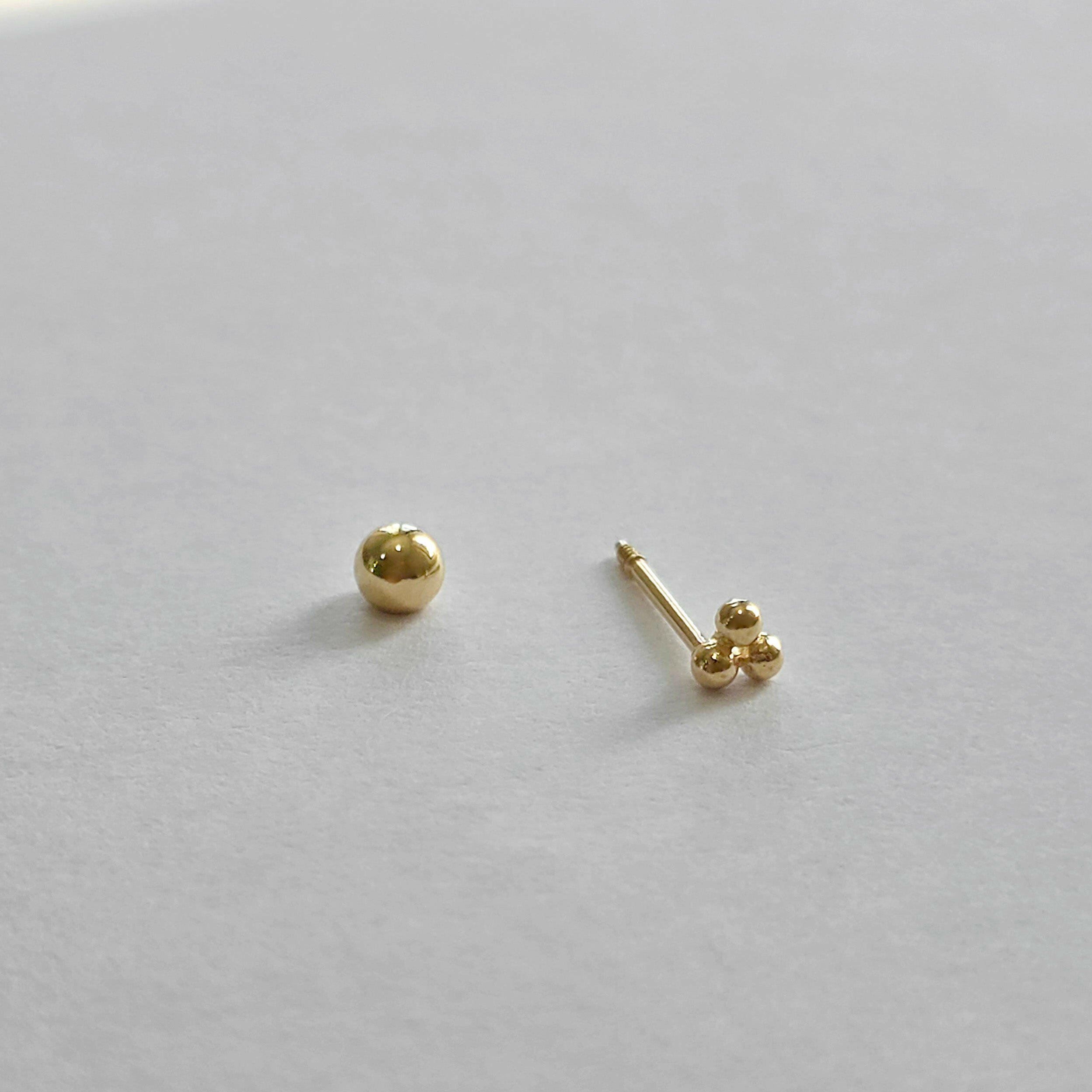 Close-up of screwball back on trio ball cartilage earring
