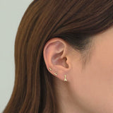 Modern gold ear layering featuring abstract curved line stud