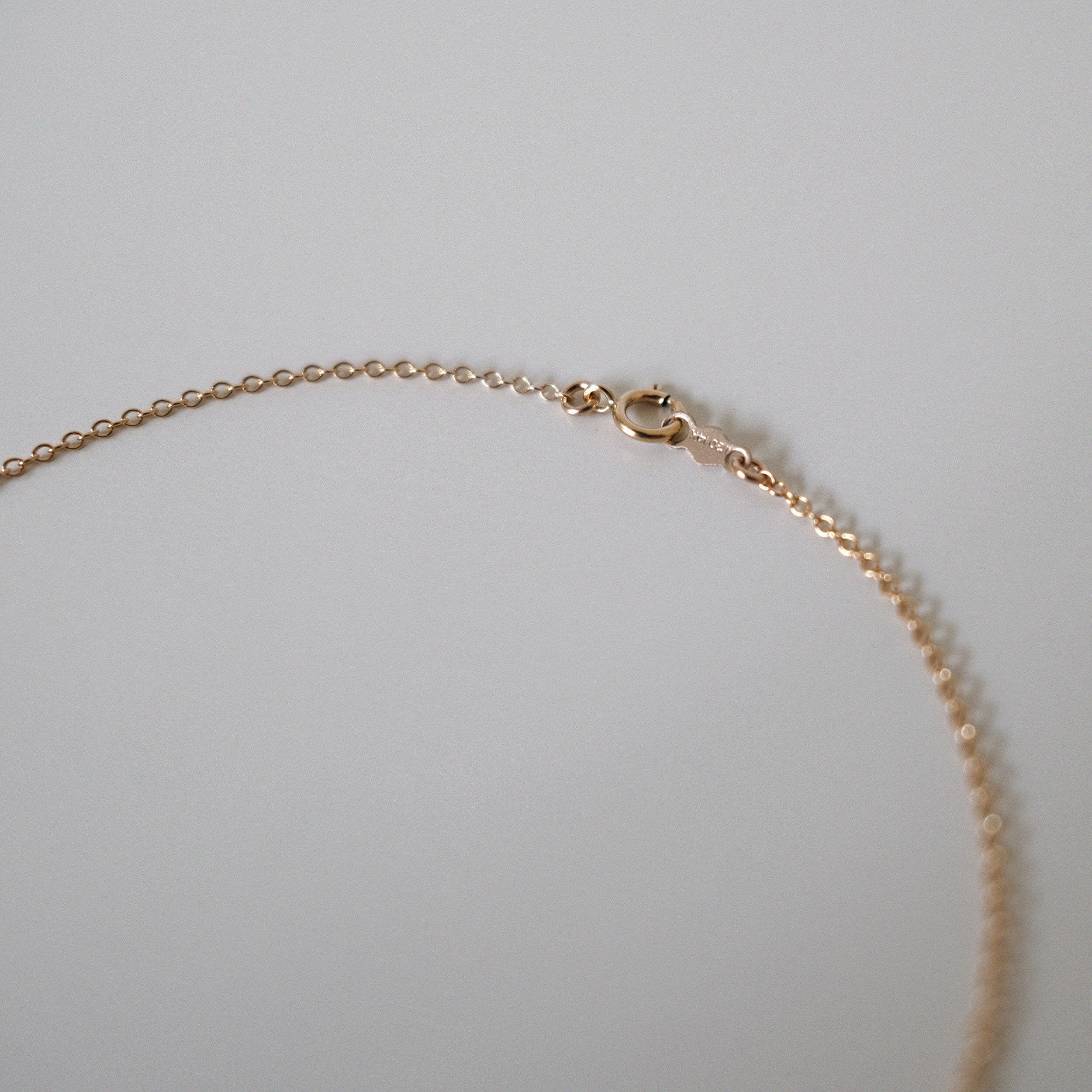 Close-up of spring ring clasp and chain connection to pearl