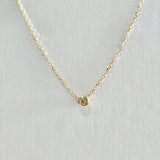 Close-up of bezel-set diamond pendant in 14K gold – radiant, minimalist design