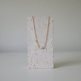 Necklace on stone stand showing pendant symmetry