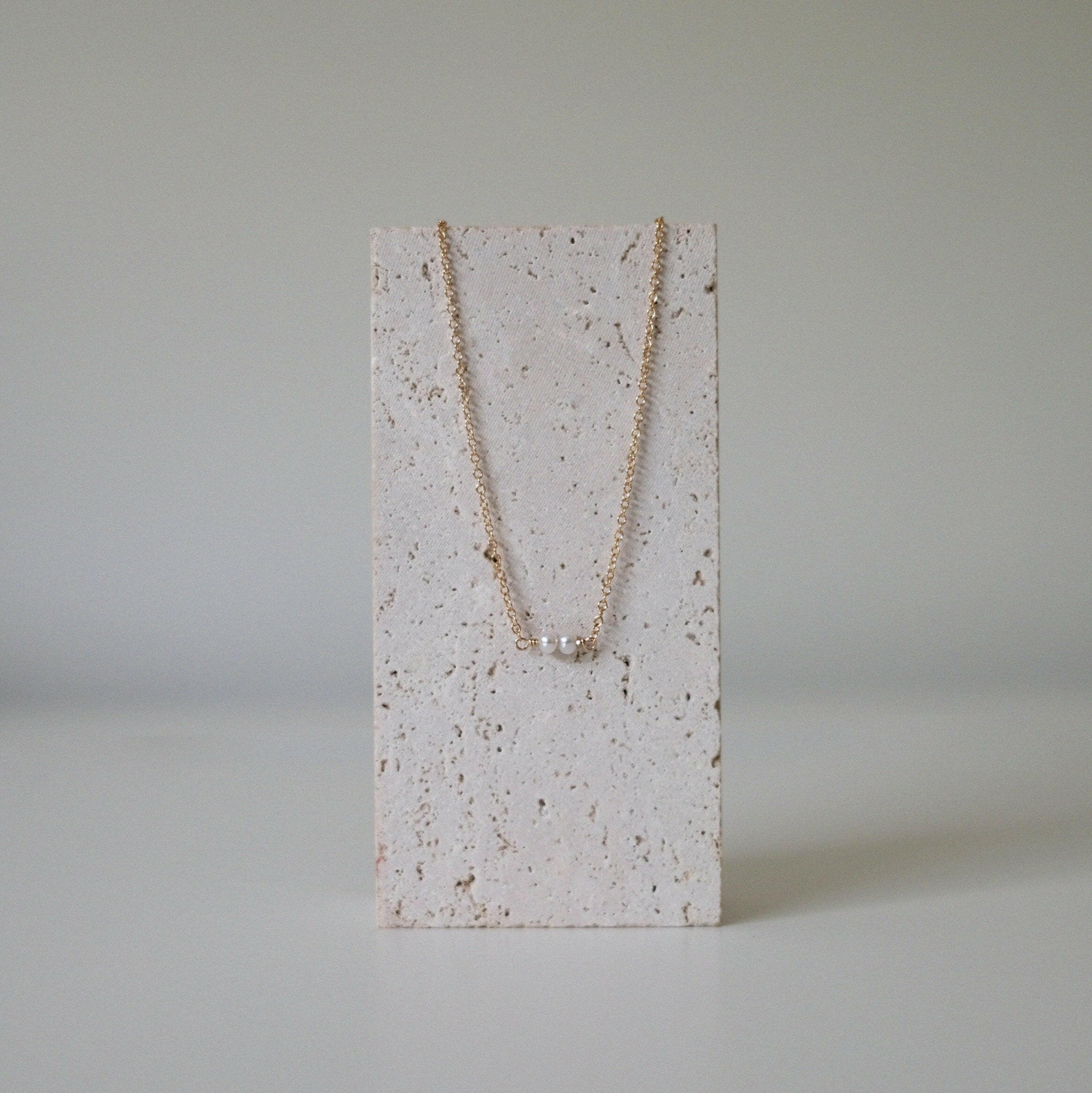 Necklace on stone stand showing pendant symmetry