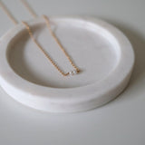 Close-up of two freshwater pearls centered on fine chain